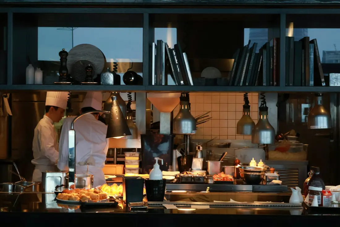 Chefs working the pass in a busy restaurant kitchen